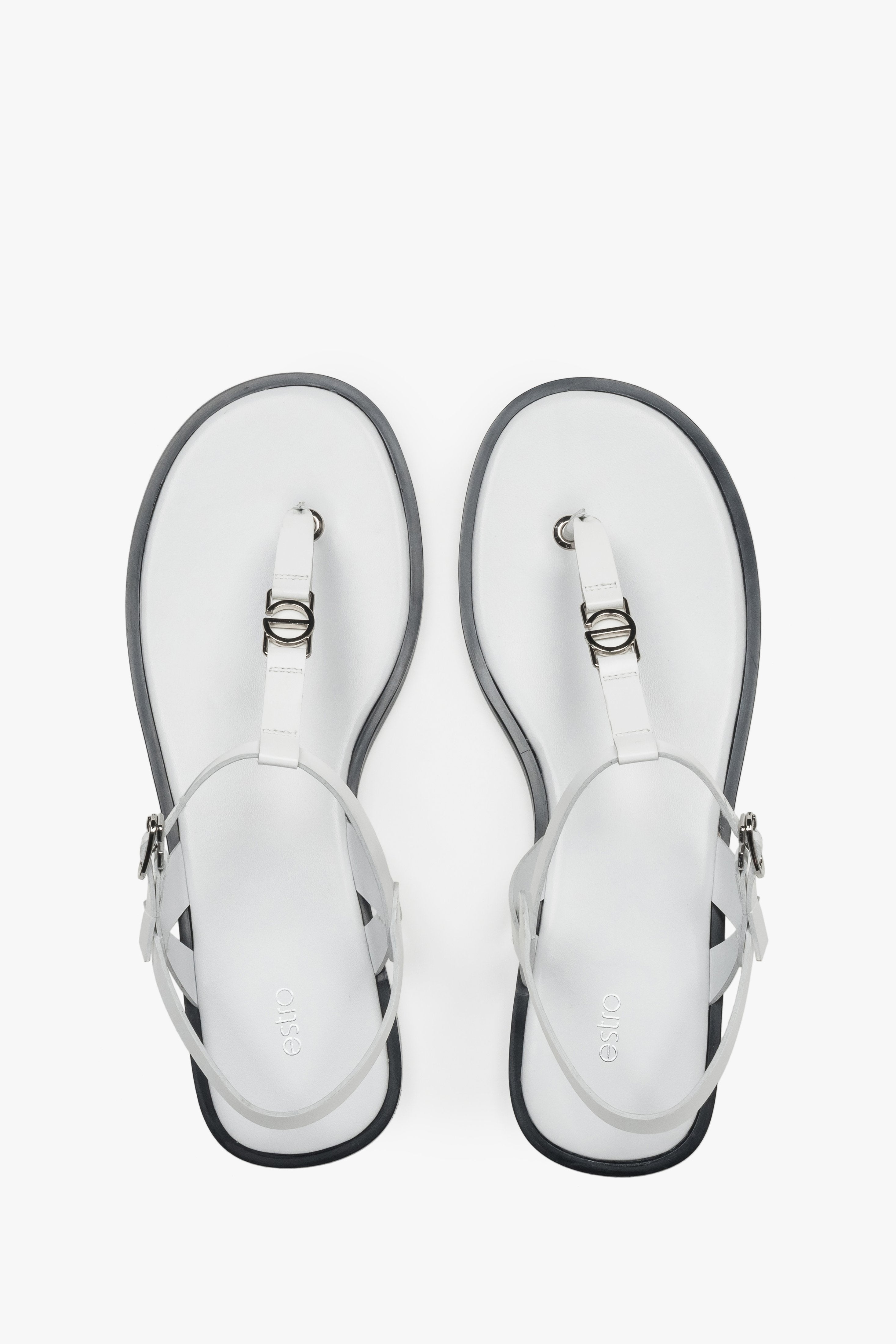 Draufsicht auf die weißen Zehentrenner-Sandalen aus Leder mit silbernen Details und dunkler Sohlenkante