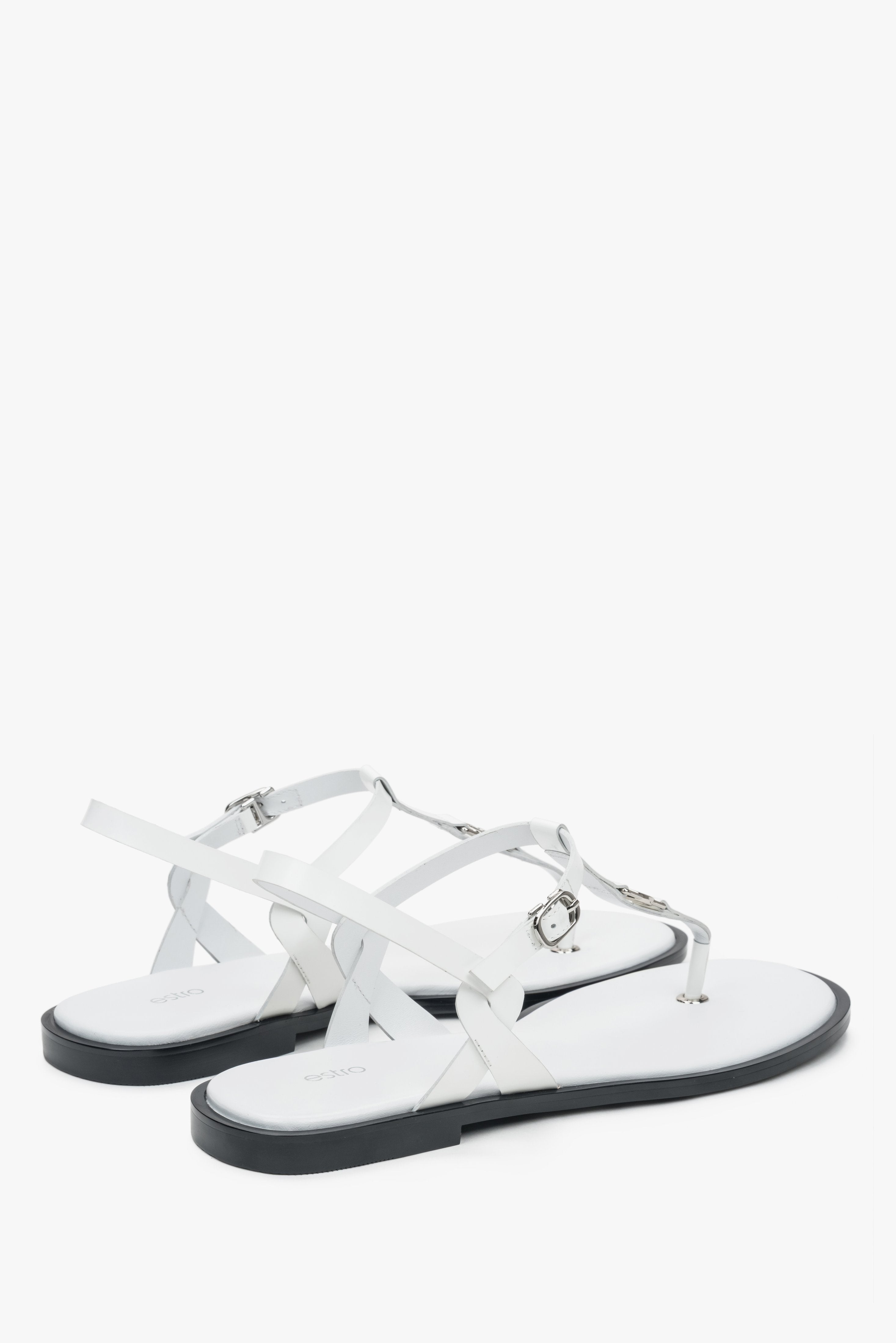 Rückwärtige Schrägansicht der weißen Sommer-Sandalen mit Fokus auf die flache Sohle