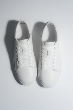 Draufsicht auf das Paar weißer Herren-Sneaker aus weichem Echtleder.