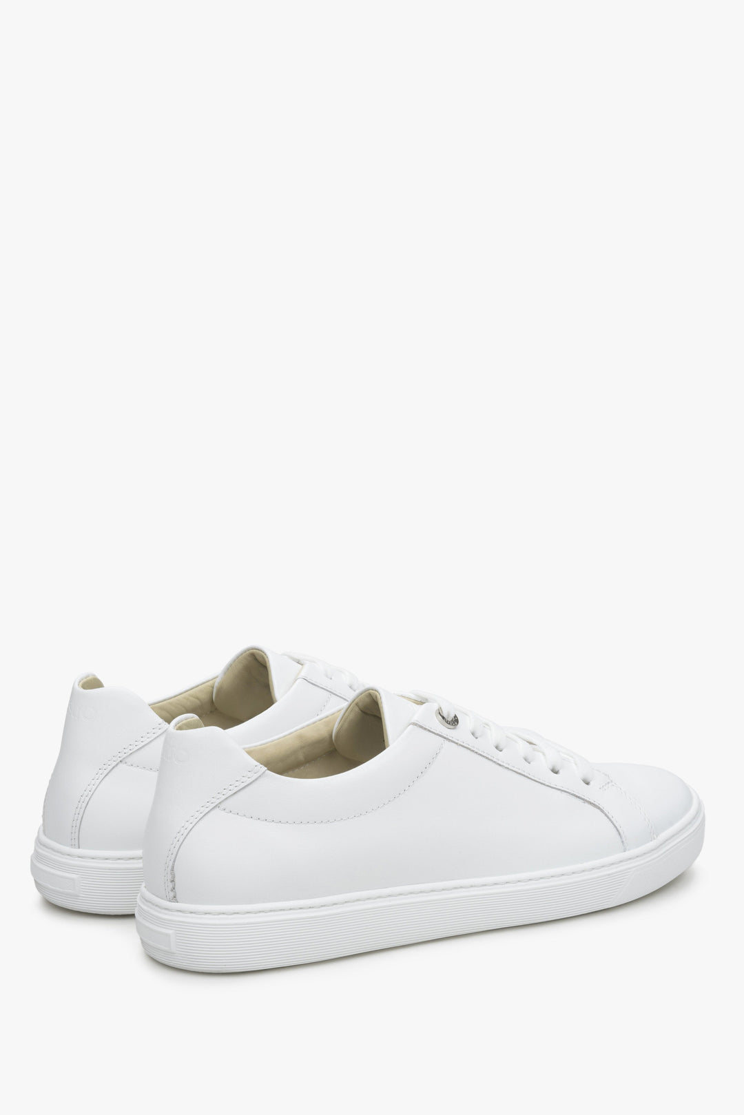 Ein Paar minimalistische weiße Leder-Sneaker mit klaren Linien und weißen Schnürsenkeln.