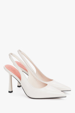 Zwei elegante weiße Damen-Pumps mit Fersenriemen und spitzer Zehenpartie.