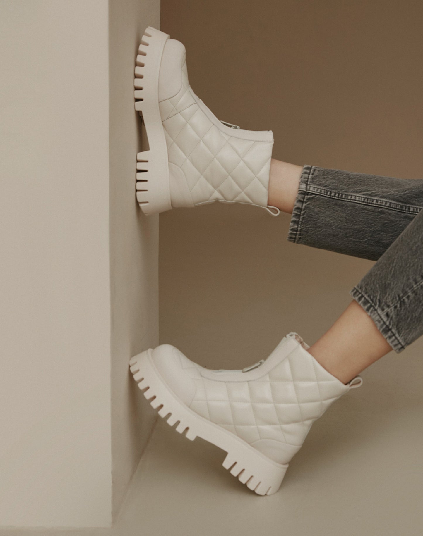 Weiße gesteppte Damen-Winterstiefeletten – Präsentation des Schuhwerks am Modell.