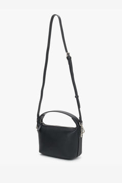 Seitenprofil der kompakten schwarzen Damen-Ledertasche mit verstellbarem Schulterriemen